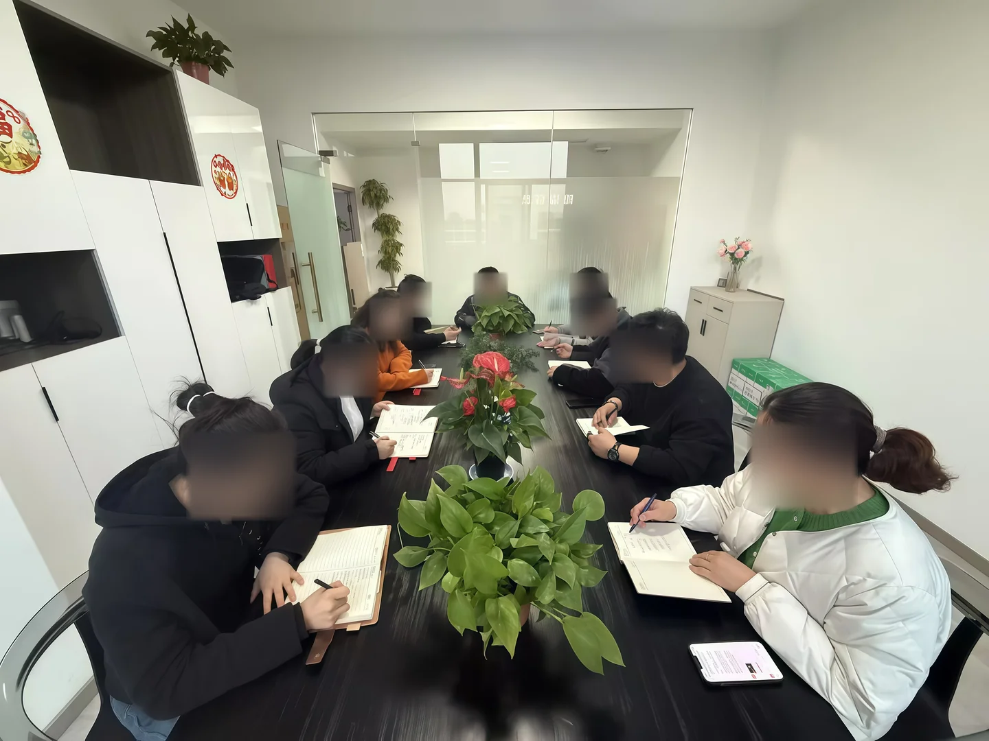团队学习交流现场，人员面部已作隐私模糊处理